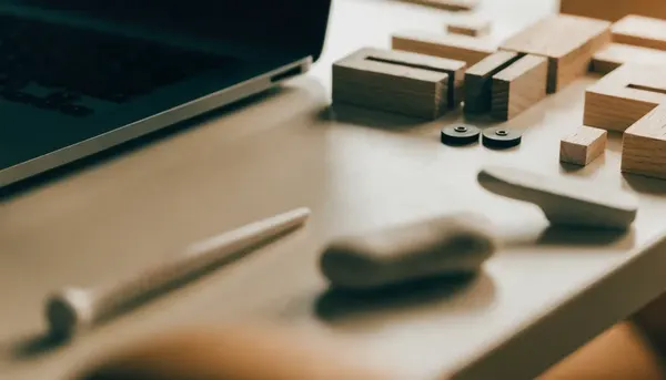 Bloques y herramientas ordenados sobre un escritorio junto a un portátil